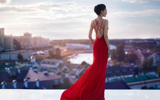 девушка в красном платье на фоне курортного города